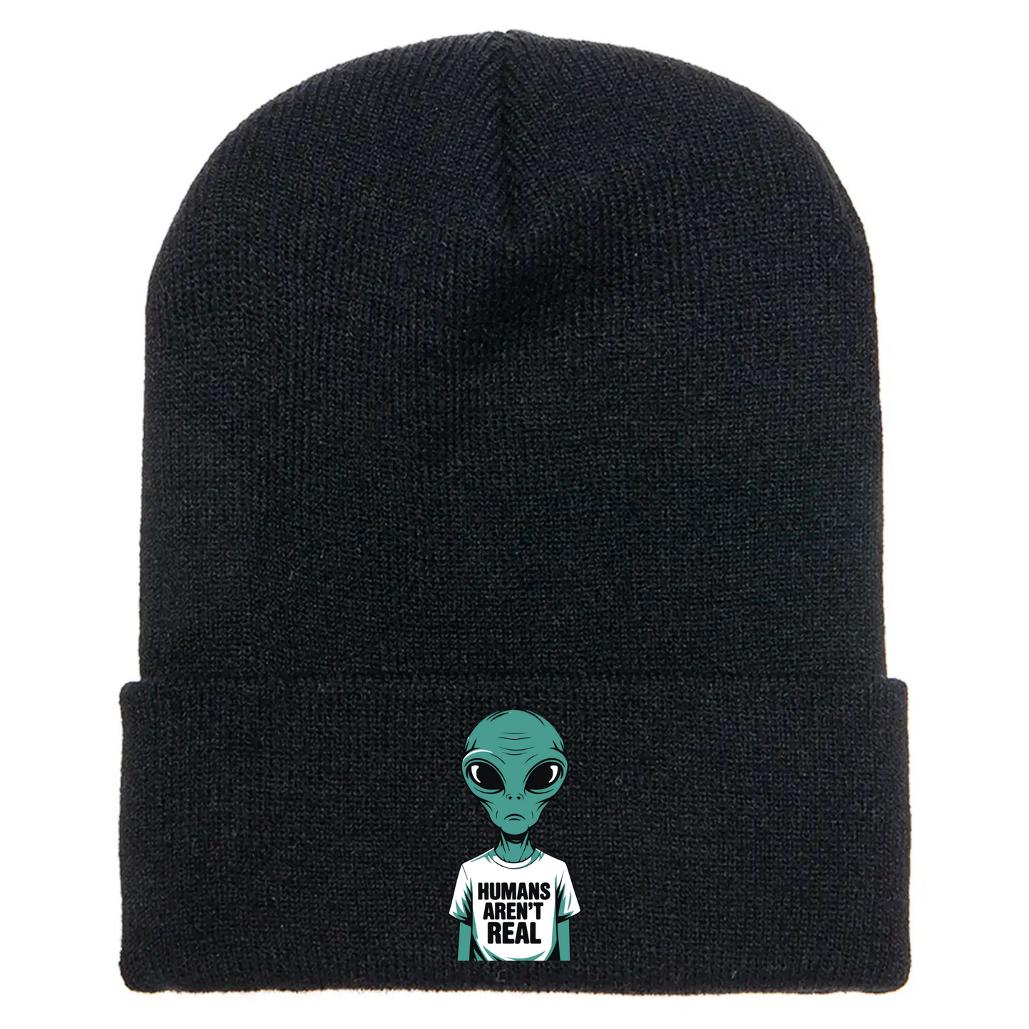 Black acrylic beanie with a cartoon alien wearing a white T-shirt that says “Humans Aren’t Real” in bold black letters.