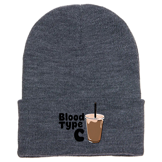 Gray cuffed beanie made of acrylic material with an image of an ice coffee and the phrase “Blood Type C”.