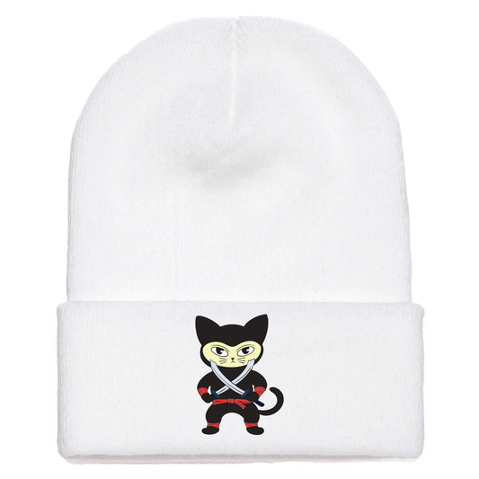 White cuffed beanie made of acrylic material with a cartoon cat in a black ninja outfit holding two crossing swords.